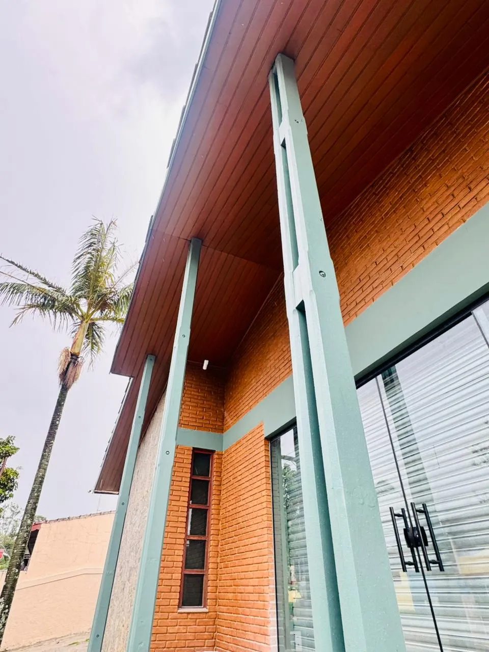 Entrada coberta da Casa Petri, com estrutura de madeira e tijolos
