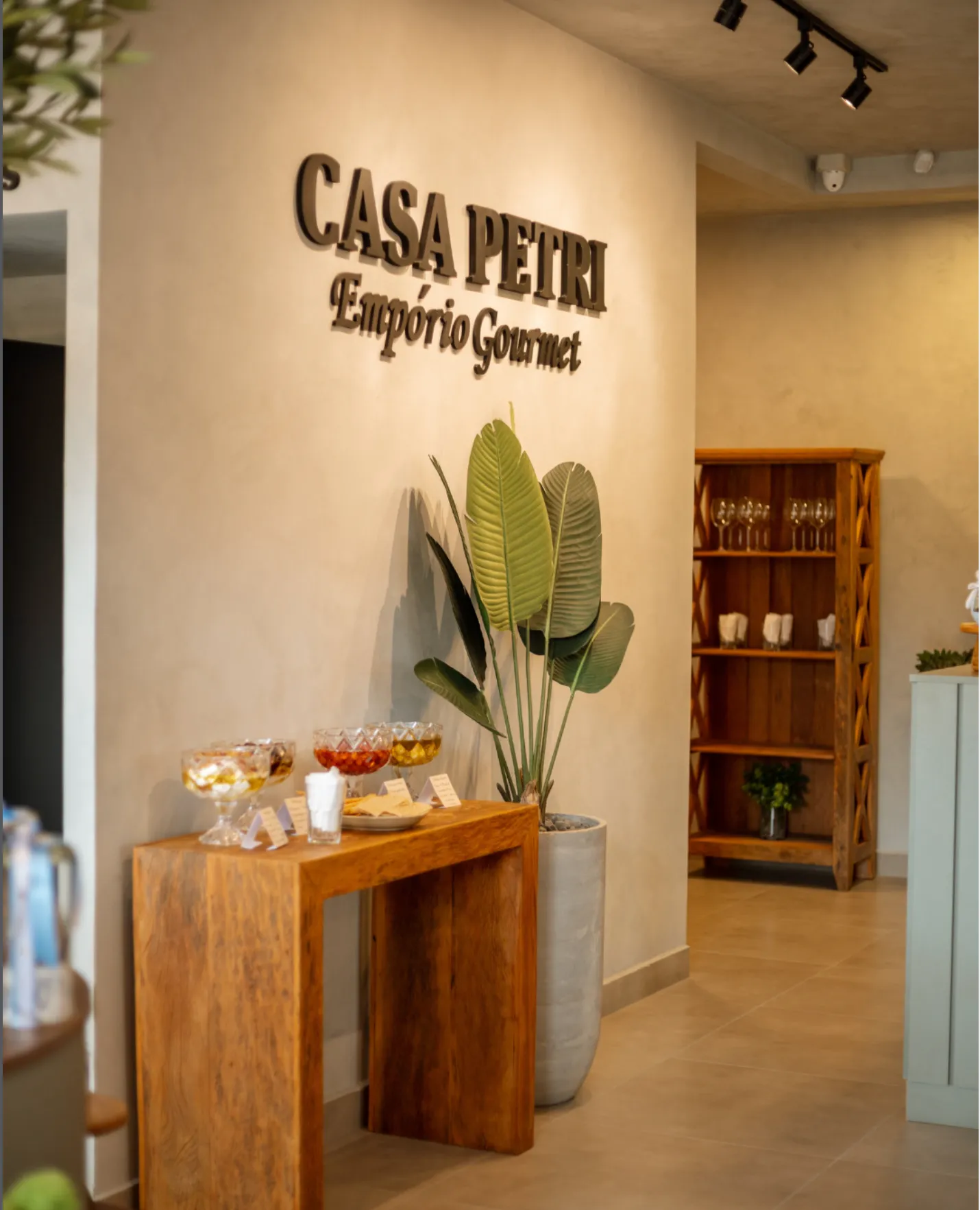Parede interna da Casa Petri com o letreiro Empório Gourmet e adega