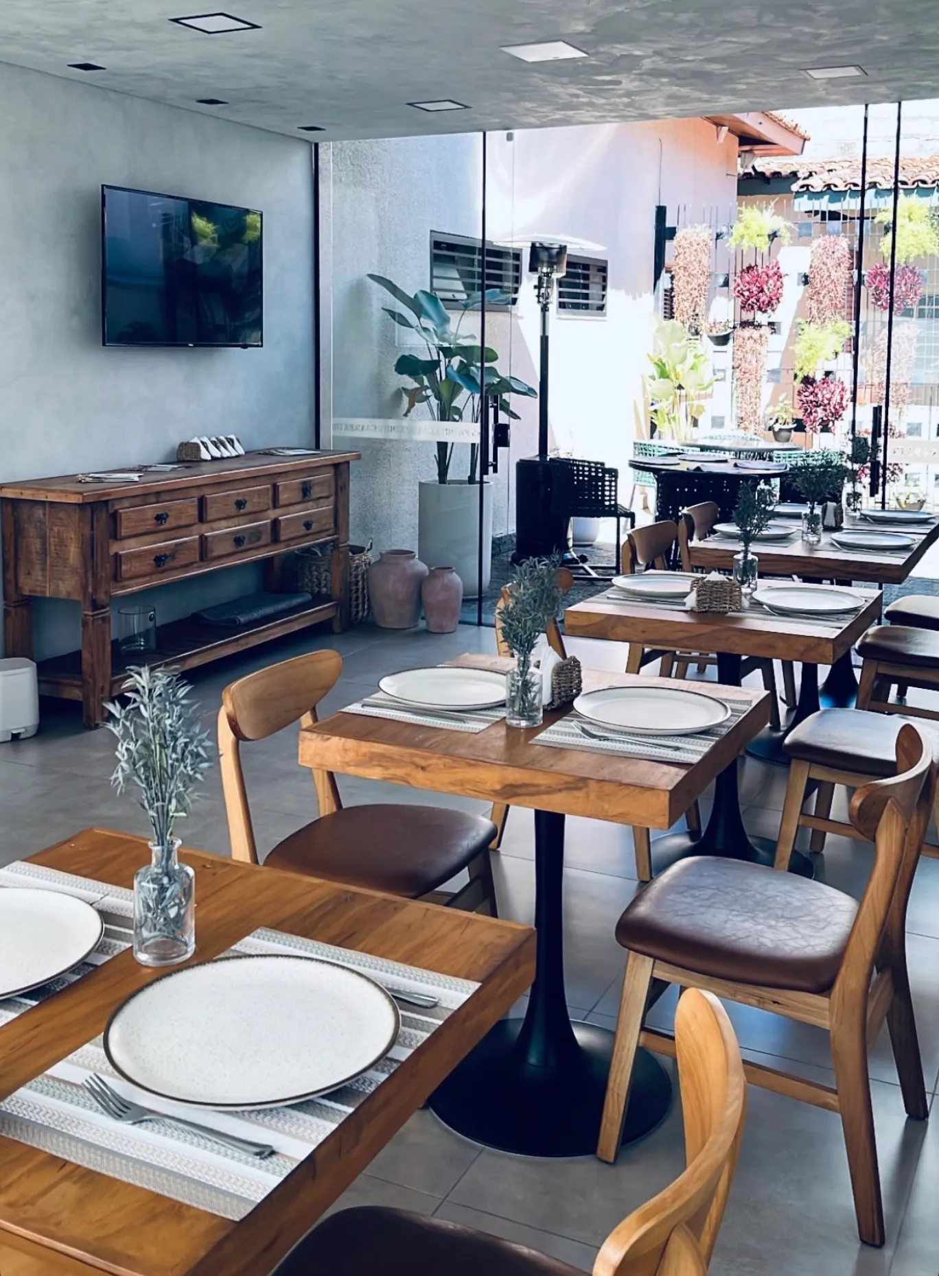 Varanda da Casa Petri com mesas, plantas e flores decorativas