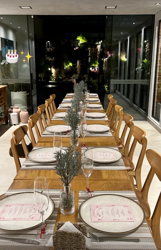Mesa longa decorada para evento na Casa Petri, com taças e cardápios personalizados