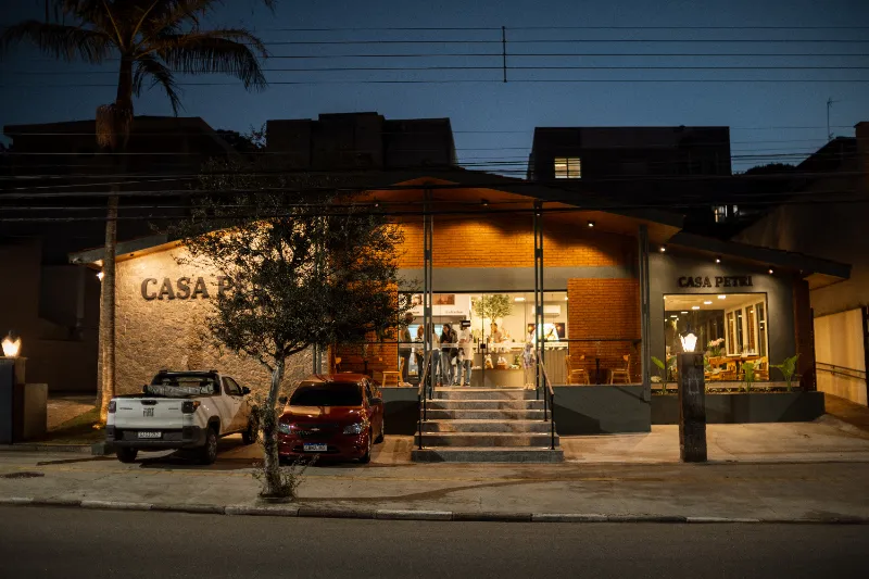 Fachada completa da Casa Petri vista da rua, ao entardecer